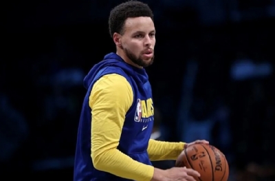 Stephen Curry TV başında önümüzdeki sezon için notlar alıyor